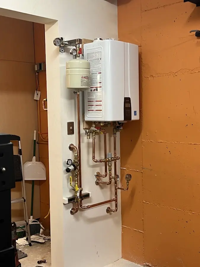 Plumbing technician inspecting water heater connections in Paris